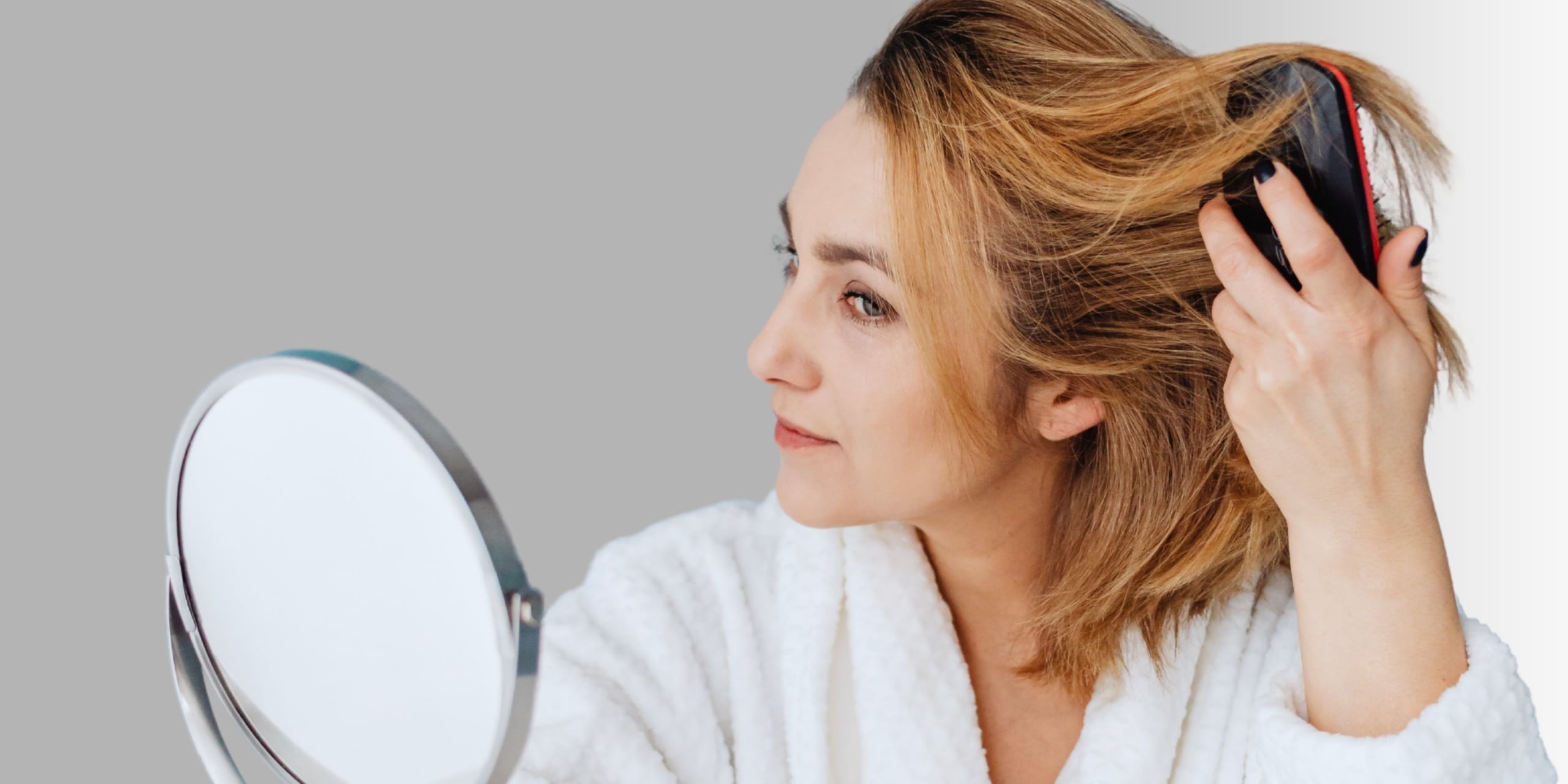 Woman brushing her thick head of hair in the mirror