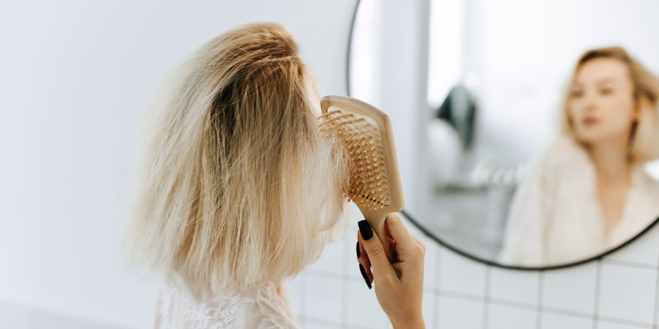 Woman brushing her hair in the mirror